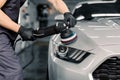 Car detailing and polishing concept. Hands of professional car service male worker, with orbital polisher, polishing Royalty Free Stock Photo