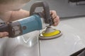 Hands of professional car service male worker, with orbital polisher, polishing white luxury Royalty Free Stock Photo