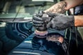 Car detailing and polishing concept. Hands of professional car service male worker, with orbital polisher, polishing yellow luxury Royalty Free Stock Photo