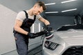 Car detailing and polishing concept. Professional Caucasian male car service worker, holding in hands orbital polisher Royalty Free Stock Photo