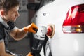 Car detailing series: polishing white vehicle in auto repair shop. Royalty Free Stock Photo