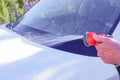 Car warhing. Worker cleaning white car on open air.Cleaning Car Using High Pressure Water. Man washing his car under Royalty Free Stock Photo