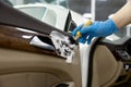 Car detailing service, closeup worker cleaning washing leather door parts with brush