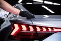 Car detailing studio employee or car wash worker applies a ceramic protective coating