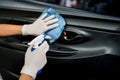 Car disinfecting service. Hands with gloves cleaning and car door with rag and atomizer