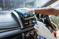 Car disinfecting service. Male staff worker cleaning car dashboard