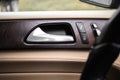 Car door handle with door lock control panel inside luxury car interior with leather