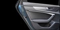 Car door handle inside the luxury modern car with black leather texture with stitching. Switch button control. Modern car interior