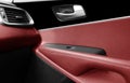 Car door handle inside the luxury modern car with red leather interior. Switch button control. Modern car interior details. Red Royalty Free Stock Photo