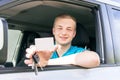 Car driver. Caucasian teen boy showing an empty white card, car Royalty Free Stock Photo