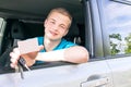 Car driver. Caucasian teen boy showing an empty white card, car