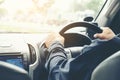 Car driver hands holding steering wheel.