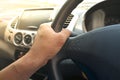 Car driver keeps driving wheel one hands.