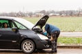 The car driver refilling the blue non-freezing windshield washer liquid in the tank of the car Royalty Free Stock Photo