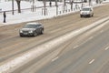 car drives during the day along an empty winter snowy street in the city