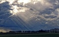 Sun rays through cloud gaps, dramatic sky over the countryside Royalty Free Stock Photo