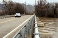 Car drives over bridge during flood