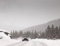 Car driving along snow covered road in a snowstorm Royalty Free Stock Photo