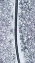 a car driving along a snowy road surrounded by trees with one red car Royalty Free Stock Photo