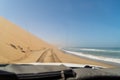 Car driving at dirt road in desert. Sand drive at the beach. Coast of sea. Royalty Free Stock Photo