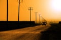 Car Driving Down Country Road Headlights Power Lines and Poles Royalty Free Stock Photo