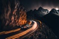 a car driving down a road with mountains in the background at night time with lights on the road and a mountain in the foreground Royalty Free Stock Photo