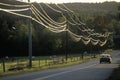 A car driving down a road with power lines during sunset in Wheelock, Vermont