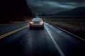 Car driving fast on the countryside road at dusk. Autumn rural landscape and sky with clouds Royalty Free Stock Photo