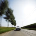 Car driving fast down road Royalty Free Stock Photo