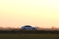 Car driving fast on intercity road at sunset. Highway traffic in evening