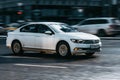 Car driving fast motion on the highway, side view. White Volkswagen Passat B8 is moving on the street