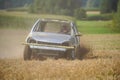 A car is driving through a field of dry grass Royalty Free Stock Photo