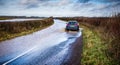 Car driving through flooded road near Nunney In Somerset, UK