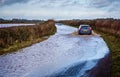 Car driving through flooded road near Nunney In Somerset, UK