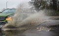 Car driving through Flooded road splashing sidewalk / pavements