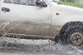 Car driving on a flooded road with water and splashes caused by heavy rain. Royalty Free Stock Photo