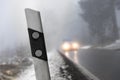 Car driving on a foggy winter forest street Royalty Free Stock Photo