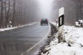 car driving on a foggy winter forest street Royalty Free Stock Photo