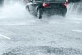 Car driving In high speed through big water puddle during heavy Royalty Free Stock Photo