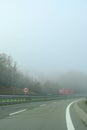 car driving on a highway covered with strong fog. Red truck driving from the opposite lane. Transportation. bad weather