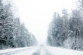 Car Driving on highway trough a forest in a snow storm on Royalty Free Stock Photo