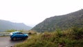 Car driving on the hills road with hair pin bend, slow and safe, mountain background.