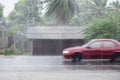 Car driving motion through gale rain on front wooden house