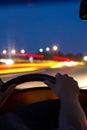 Car driving at night. View from inside the car. Mens hands on steering wheel Royalty Free Stock Photo