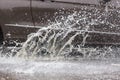 Car driving through a puddle on a flooded road with water and splashes caused by heavy rain. Royalty Free Stock Photo