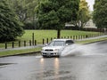 Car driving through puddle. Heavy rain. Auckland, New Zealand - January 27, 2023