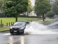 Car driving through puddle. Heavy rain. Auckland, New Zealand - January 27, 2023