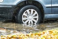 The car is driving through a puddle in heavy rain. Splashes of water from under the wheels of a car. Flooding and high water in Royalty Free Stock Photo