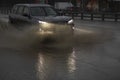 The car is driving in a puddle. Sprays from under the wheels Royalty Free Stock Photo