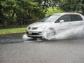 a car that is driving through a puddle of water in the street